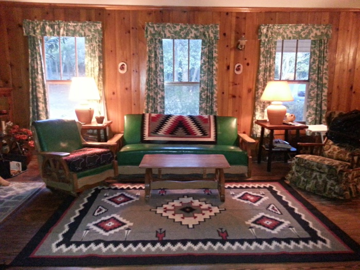 Grey w red black and white Navajo Design wool rug in cabin setting